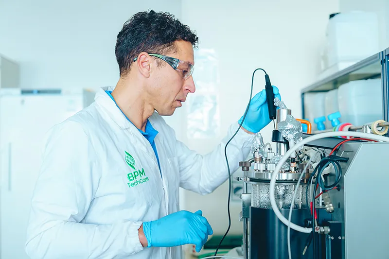 Technicien ajustant un équipement de biotechnologie, mettant en avant la maintenance et le savoir-faire industriel AKTA