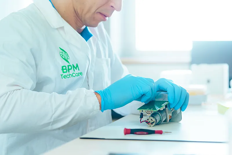 Assemblage minutieux d’un composant électronique en laboratoire, démontrant la rigueur et l’expertise technique en environnement contrôlé